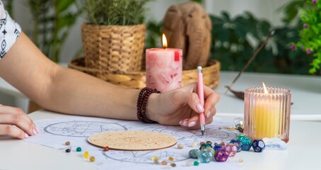 Woman astrologer draws a natal chart. Selective focus