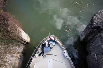 Vue plongeante d'un bateau passant une écluse. Bateau dans un passage étroit. Bateau entre 2 murs...