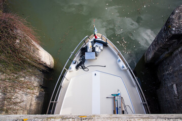 Vue plongeante d'un bateau passant une écluse. Bateau dans un passage étroit. Bateau entre 2 murs...