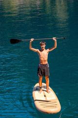Young man relaxing on his paddle board during summer vacation.