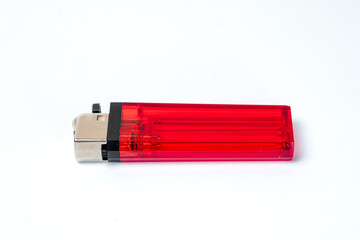 A close-up of a red lighter resting on a white background, highlighting its sleek design and functional features, ideal for various lighting needs.