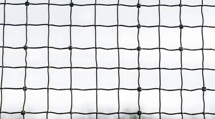 A close-up of a black mesh netting with a grid pattern, set against a soft, blurred background, showcasing a minimal and modern aesthetic.  