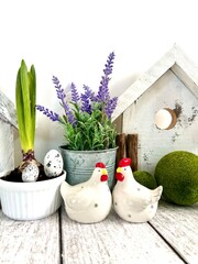 Easter decorative composition, home decoration for the bright Easter holiday. On a light background, cute chickens and wooden houses, front view, Easter style.
