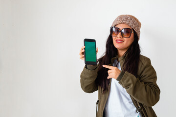 Hermosa joven mujer con chaqueta trabajo feliz mientras usa un teléfono inteligente mirada a un espacio publicidad y aislada en un fondo celular pantalla verde ,gris,contactar,celular,