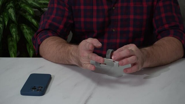 the guy removes the orthosis from his finger after recovery. a medical fixation device that provides joints and ligaments with a physiological position.