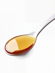 Spoon filled with golden syrup displaying a rich texture and vibrant color in a clean, minimalist setting