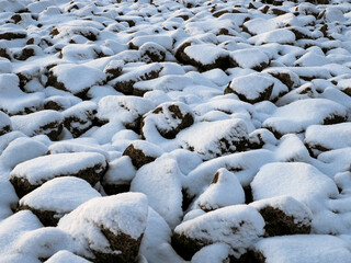 the artificial embankment or bank made of huge granite blocks covered with snow