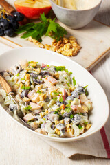 Waldorf salad with apples, celery, grapes and walnuts, dressed with mayonnaise and sprinkled with parsley.