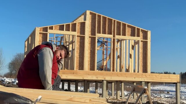 Sad angry man having problems with construction of her wooden house