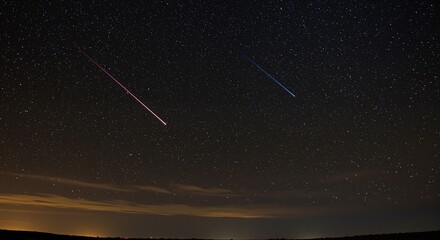 Naklejka premium Starlit night sky with shooting stars illuminating the dark expanse, creating a magical and serene atmosphere above the tranquil landscape