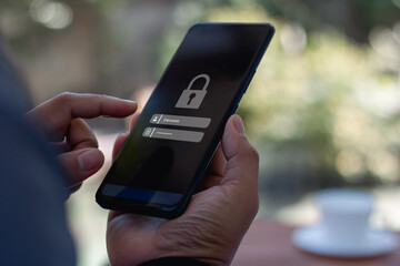 Cyber security concept. Hand holding a smartphone to login username password on screen. Data privacy online protection on mobile phone application with 2FA increases security. Secure internet access.