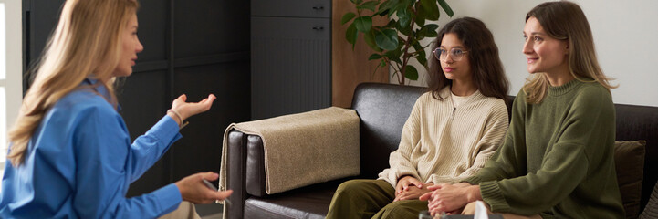 Header image of family therapy session scene with female therapist talking to mother and daughter helping with child mental health issues