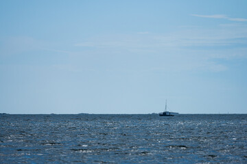 Small fishing boat at sea on a sunny windy day.