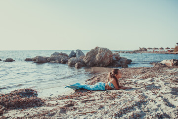 Young girl portrait in mermaid costume on the beach near sea