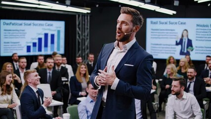 Successful businessman presenting and speaking to audience at corporate meeting, engaging with attendees and delivering an inspiring speech