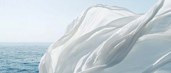 Obraz premium White flowing fabric billows in the wind near the ocean water