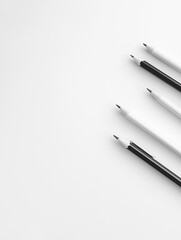Naklejka premium Black and white pencils arranged on a white surface. Minimalist stationery.