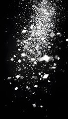 Sparkling white particles and glitter falling against a dark background