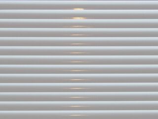 Cream Venetian blinds with light closeup abstract