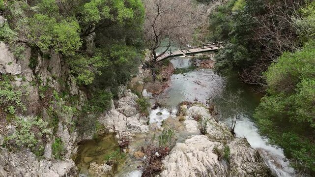 Aerial View of cascade rushes down the rocky cliffs near Polylimnio Waterfall in Messinia, Greece after heavy rainfall