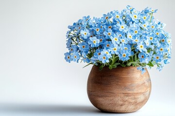 A bouquet of delicate blue forget-me-not flowers in a rustic wooden vase.