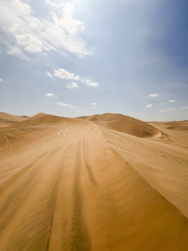 Expansive sand dunes under a blue sky in Ica, Peru