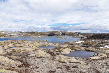 Breathtaking Landscape with Rocky Terrain and Serene Water Bodies in a Remote Location Under a Colorful Sky with Clouds and Snow-Capped Mountains in the Distance