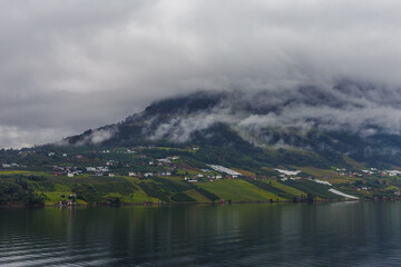 A Serene View of Misty Mountains Over a Calm Lake Amidst Lush Green Vineyards and Quaint Villages...