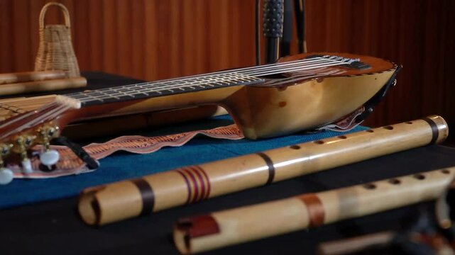 Close-up of Andean instruments like charango, wooden flutes, and percussion on textile.
