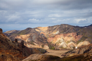 Breathtaking View of Colorful Mountain Ranges and Unique Geological Features in the Icelandic Highlands Under a Dramatic Sky Filled With Clouds