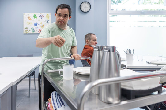 Man with Down Syndrome Helping Set the Table in a Day Center