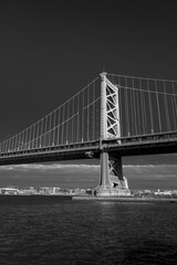 Black and white vertical image of one of the towers of the Ben Franklin Suspension Bridge spanning the Delaware River between Camden NJ and Philadelphia PA