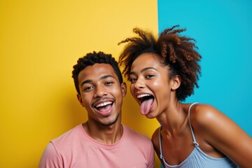 Joyful Young Black Couple with Natural Hair Playfully Posing Against Vibrant Yellow and Teal Background, Capturing the Essence of Fun and Friendship