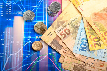 Brazilian currency notes and coins with chart