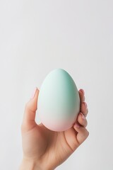 Hand holding pastel colored easter egg celebrating spring holidays