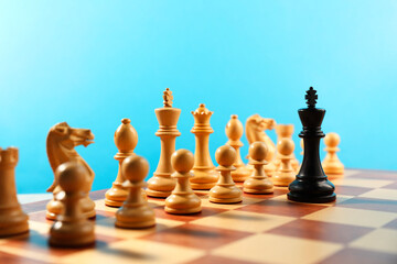 Black king in front of other white chess pieces on chessboard. Competition concept