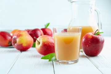 Refreshing apple juice and fruits on white wooden table