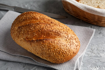 Freshly baked bread with seeds on grey table, closeup