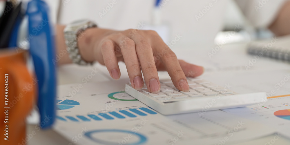 Poster close-up of a hand pressing keys on a calculator, surrounded by financial charts and data.