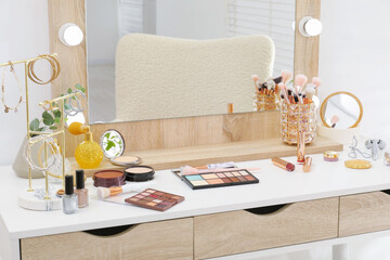 Makeup room. Dressing table with mirror, different beauty products and jewelry indoors