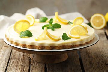 Delicious lemon cheesecake with mint on wooden table, closeup