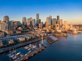 Naklejka premium Seattle skyline at sunrise, boats docked at waterfront, vibrant city life. Waterfront, Seattle, Washington, USA