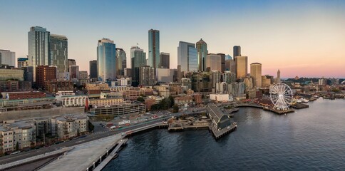 Fototapeta premium Seattle skyline at dusk, featuring the iconic Ferris wheel. Urban cityscape, waterfront, and harbor. Beautiful evening light. Waterfront, Washington, USA
