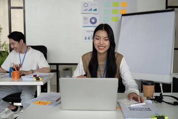 Young professional analyzing tax refund data on a laptop in a modern office setting.