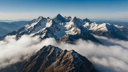 Snow-covered mountain peaks rise majestically above the clouds in a vast, scenic landscape.