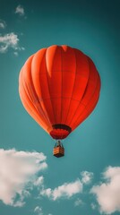 Naklejka premium Red hot air balloon soaring, blue sky, clouds, travel