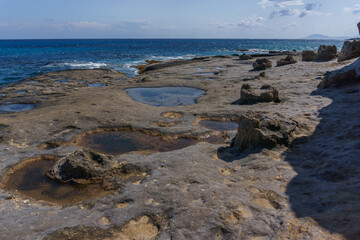 Petrified tree trunks at beautiful landscape of Geopark of Agios Nikolaos Petrified Forest at mediterranean sea coast, Laconia, Peloponnese, Greece