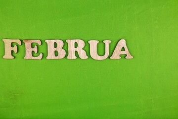February spelled with wooden letters on a solid green background. A simple and clean composition ideal for calendars, seasonal themes, and promotions.
