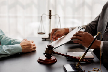 Judge gavel with Justice lawyers having team meeting at law firm background. Concepts of Law and...
