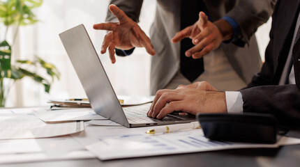 Team of confident business people point to graphs and smartphone use charts to analyze market data, balance sheet, account, net profit to plan new sales strategies to increase production capacity.
